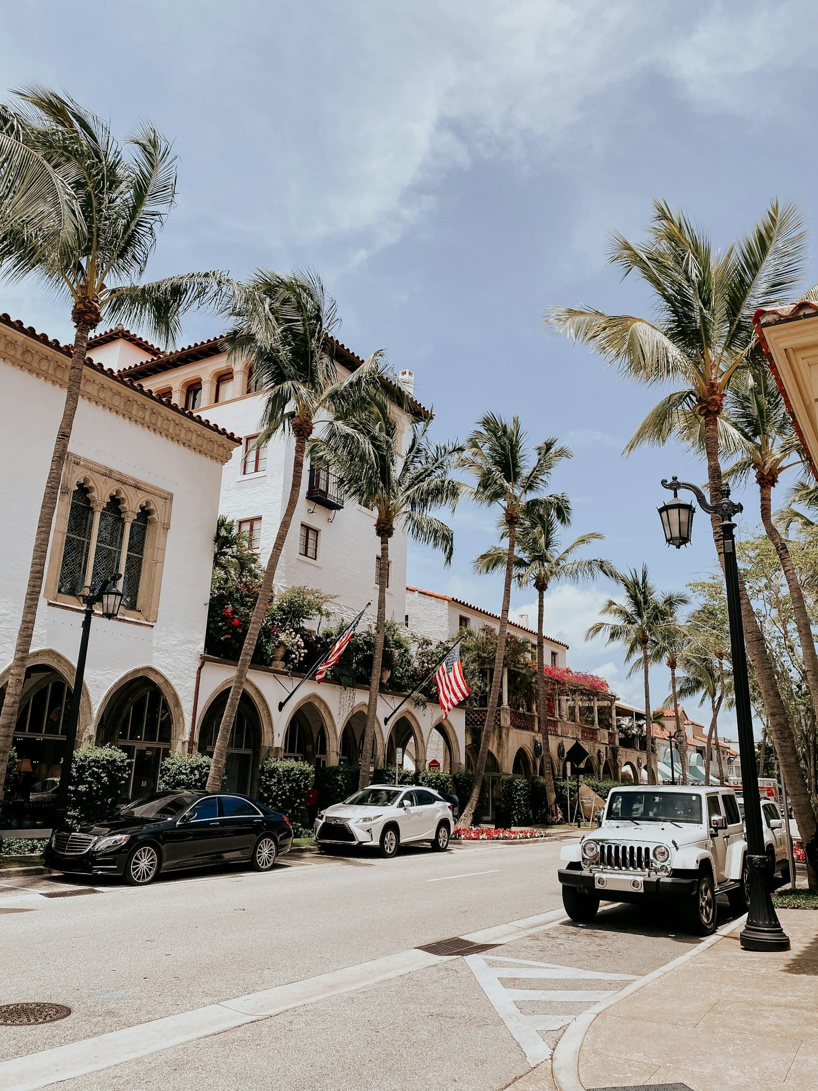 Sunny Palm Beach County street with pale storefronts and palm trees.